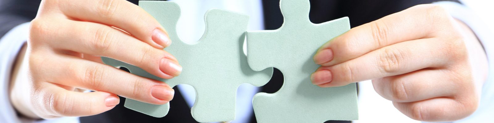 Business woman showing two jigsaw puzzle pieces . Concept for business strength and success.